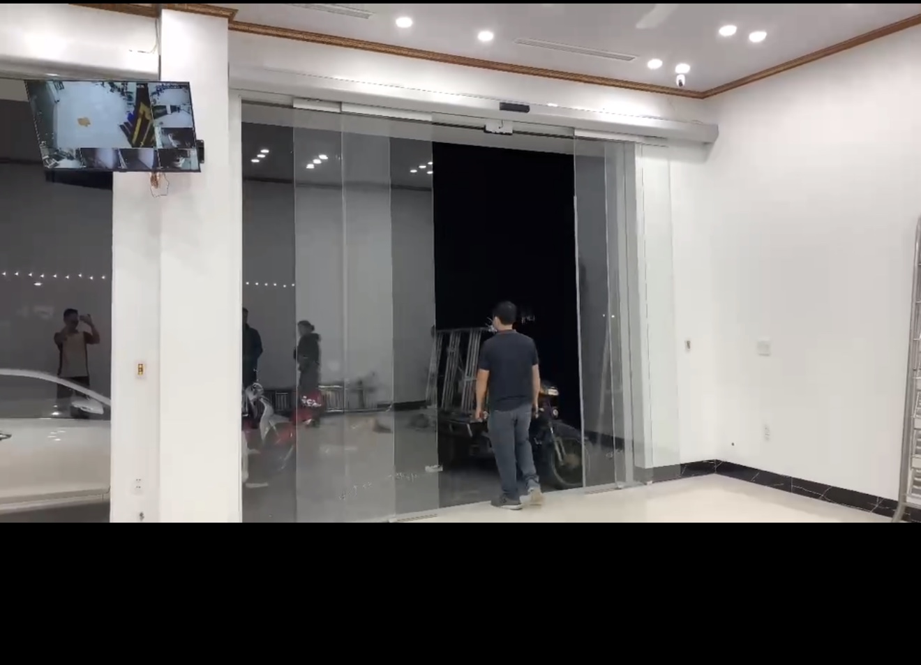 Cửa kính trượt tự động tại sảnh tòa nhà với người đàn ông đứng phía trước